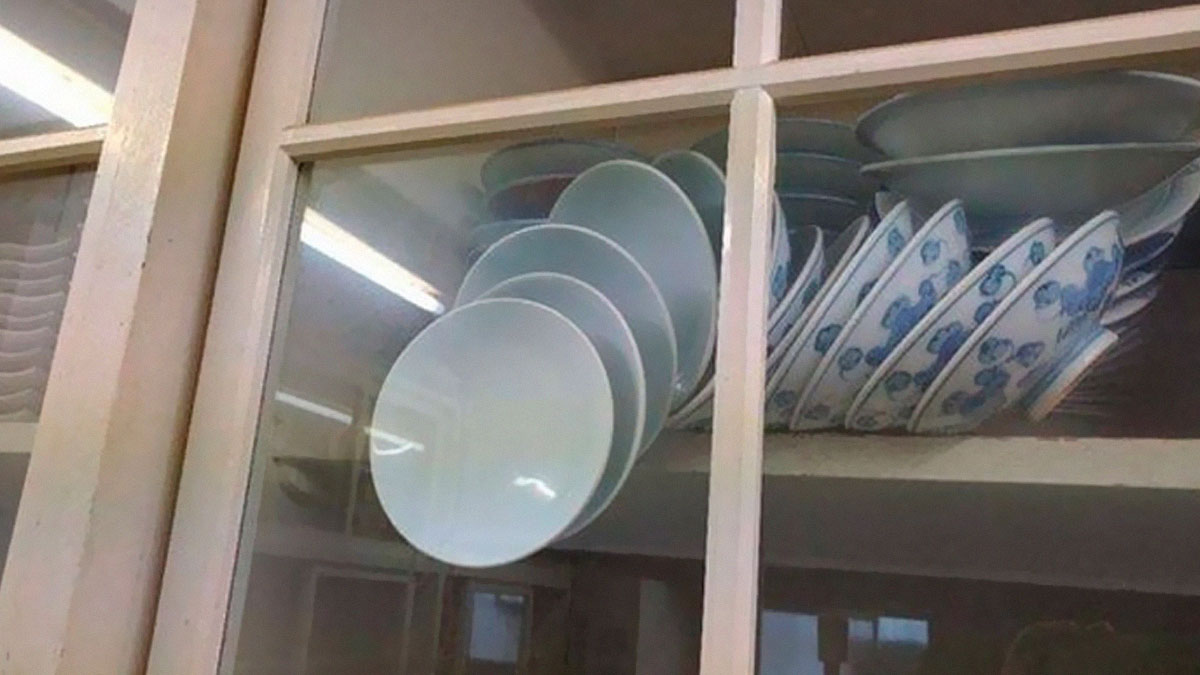 Stacked plates hanging in a cabinet displaying physics is fun concept with balance and gravity principles.