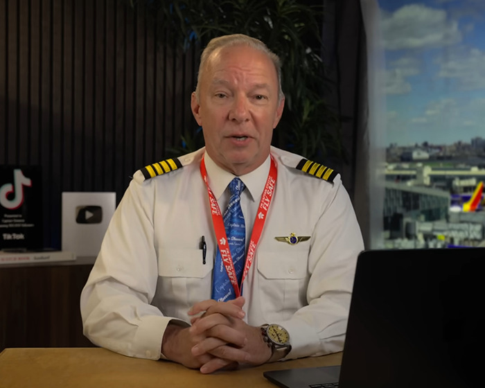 Pilot in uniform with Air India badge seated at desk, discussing new enhanced clip before plane crash investigation. Pilot in uniform with Air India badge seated at desk, discussing new enhanced clip before plane crash investigation.