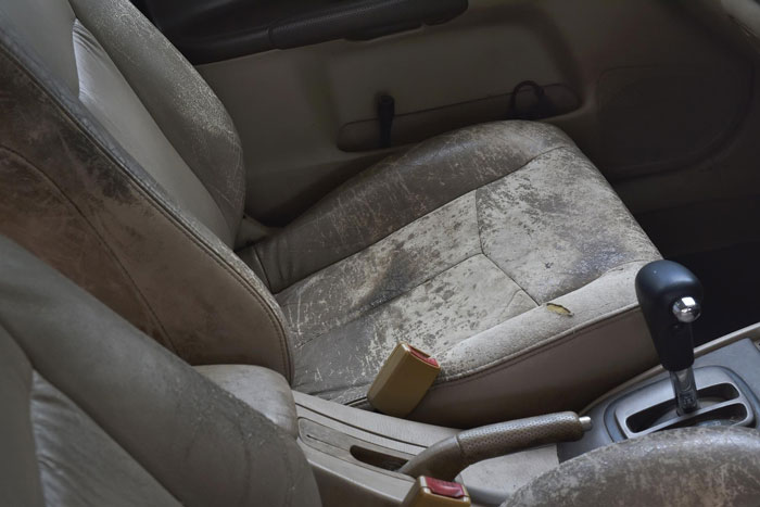 Interior of a worn Porsche car showing dirty seats and gear shift, related to parking across handicap spots incident. Interior of a worn Porsche car showing dirty seats and gear shift, related to parking across handicap spots incident.