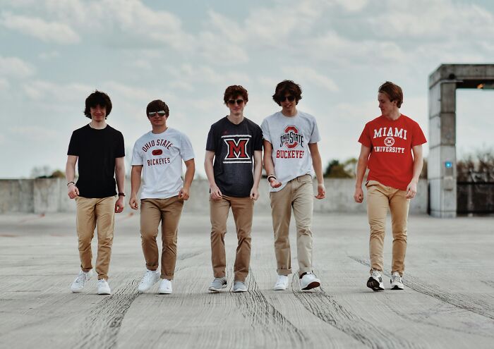 Five teenage boys walking together outdoors, representing rich kid meltdowns at private schools.