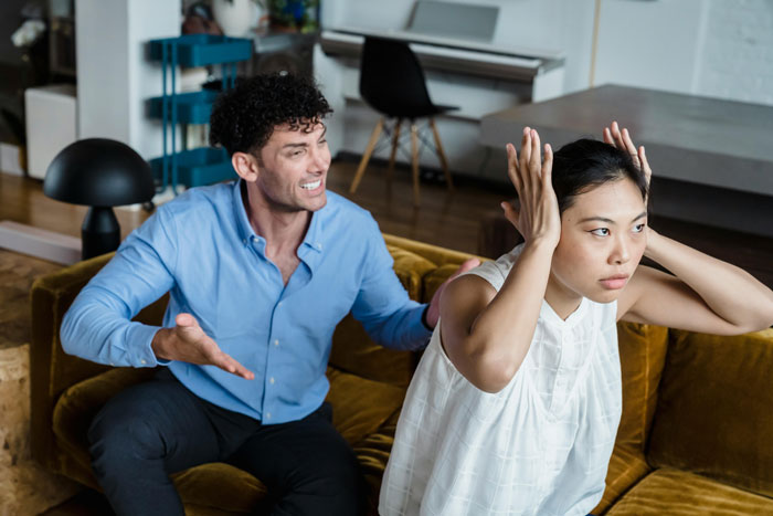 Man upset while arguing with sister on couch, reflecting tension over babysitting not being seen as real work. Man upset while arguing with sister on couch, reflecting tension over babysitting not being seen as real work.