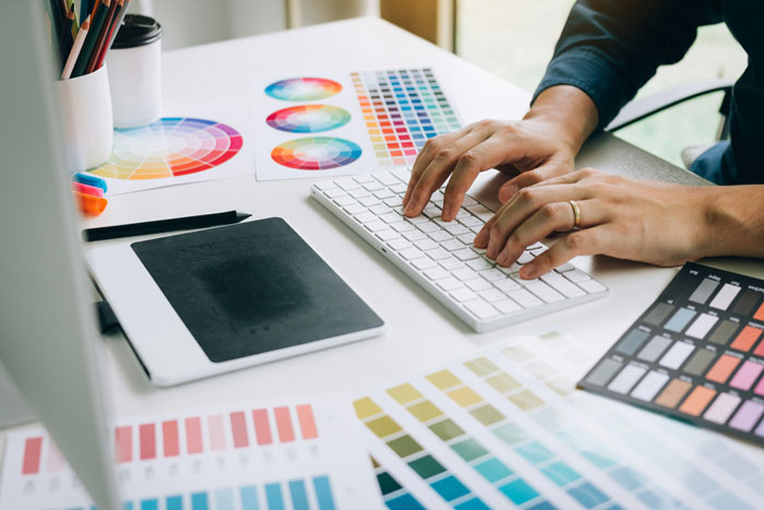 Person working on computer keyboard surrounded by color swatches, unrelated to bro quitting babysitting job debate. Person working on computer keyboard surrounded by color swatches, unrelated to bro quitting babysitting job debate.