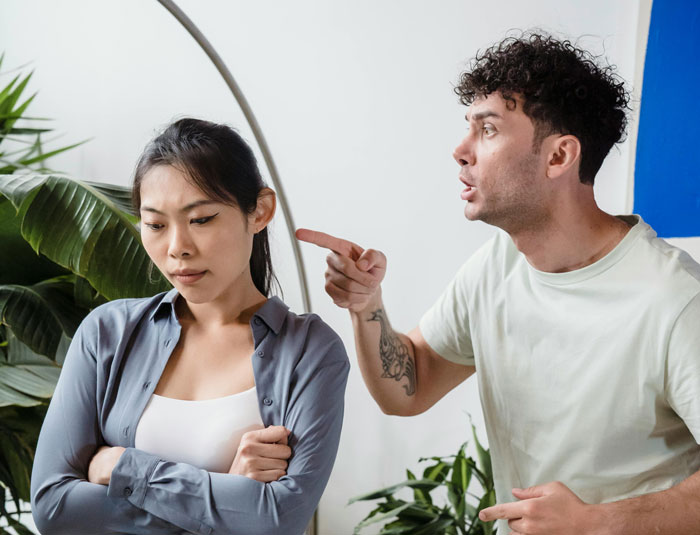 Couple arguing indoors near plants, illustrating tension around refusing to let rehome cat decisions. Couple arguing indoors near plants, illustrating tension around refusing to let rehome cat decisions.