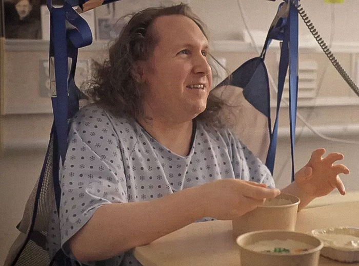 Man in hospital gown sitting and eating, highlighting issues of being trapped and mistreated by hospital staff. Man in hospital gown sitting and eating, highlighting issues of being trapped and mistreated by hospital staff.