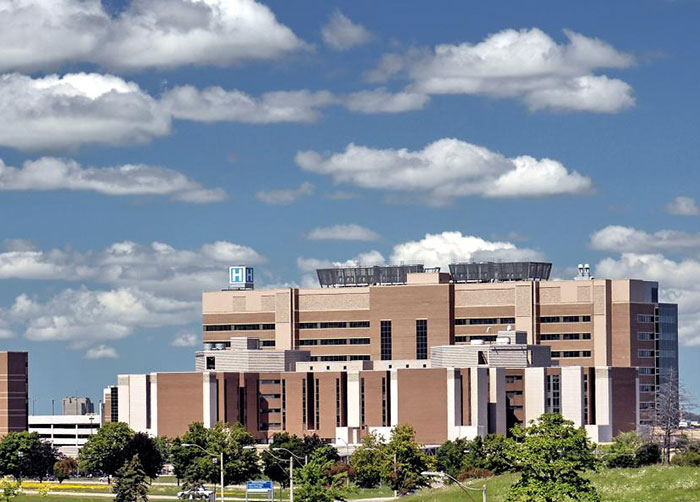 Large hospital building under a blue sky, related to man trapped in hospital for nine years exposing staff. Large hospital building under a blue sky, related to man trapped in hospital for nine years exposing staff.