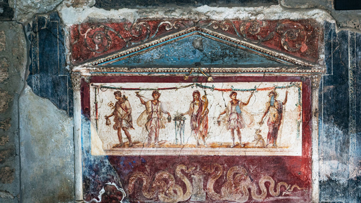 Roman comic paintings on ancient wall depicting theatrical figures and decorations in a historic empire setting.