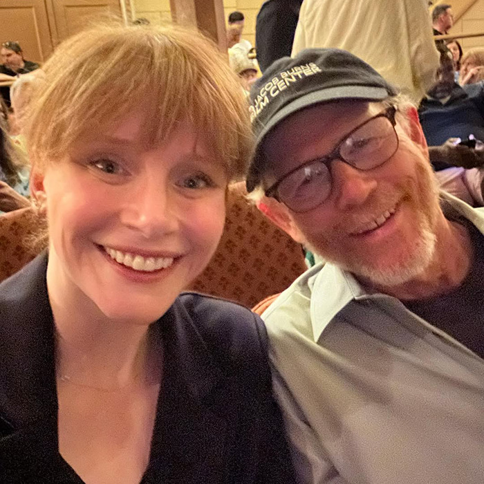 Bryce Dallas Howard and Ron Howard smiling together at an indoor event, highlighting nepo baby status. Bryce Dallas Howard and Ron Howard smiling together at an indoor event, highlighting nepo baby status.