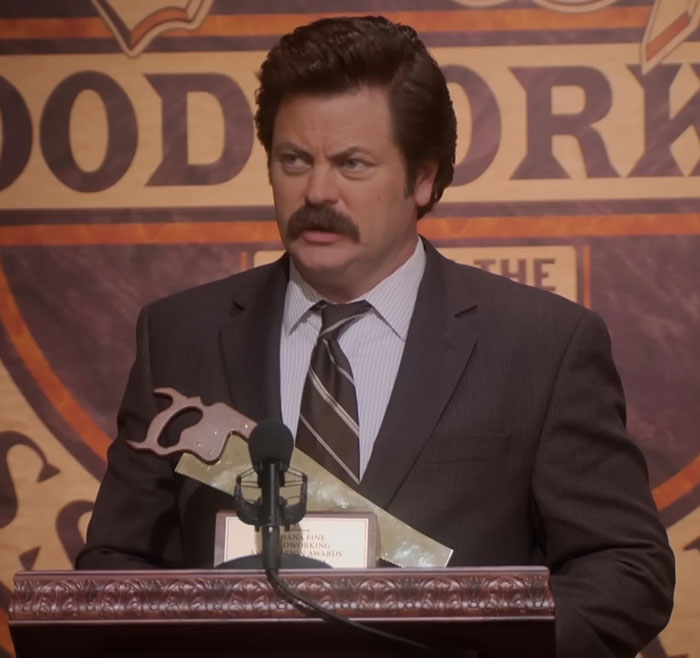Nick Offerman at a podium holding an award, delivering a speech praised for a brutal clapback against homophobe. Nick Offerman at a podium holding an award, delivering a speech praised for a brutal clapback against homophobe.