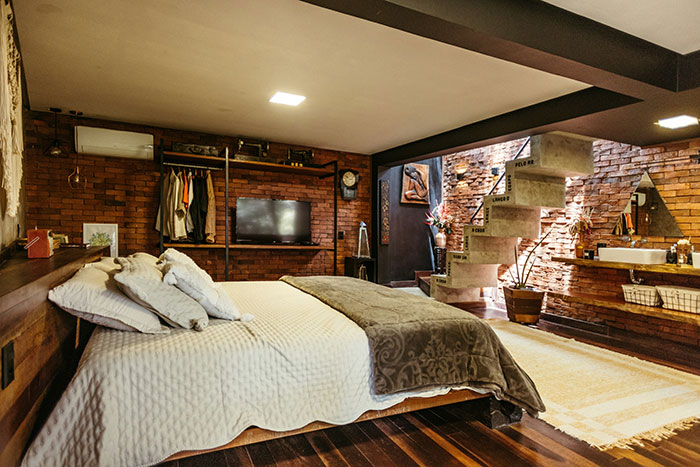 Spacious modern bedroom with exposed brick walls and wooden flooring in a couple’s home after kicking out roomie. Spacious modern bedroom with exposed brick walls and wooden flooring in a couple’s home after kicking out roomie.