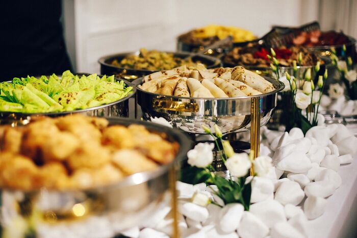 Buffet table with various dishes and flowers, illustrating people share most privileged things said at events.