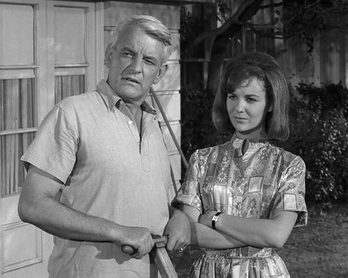 Black and white photo of iconic sitcom legend with a young woman, both standing outdoors in vintage clothing. Black and white photo of iconic sitcom legend with a young woman, both standing outdoors in vintage clothing.