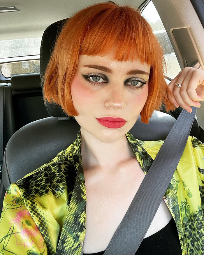 Young woman with orange bob haircut and bold makeup, wearing a patterned outfit, showcasing a child star's unrecognizable transformation. Young woman with orange bob haircut and bold makeup, wearing a patterned outfit, showcasing a child star's unrecognizable transformation.