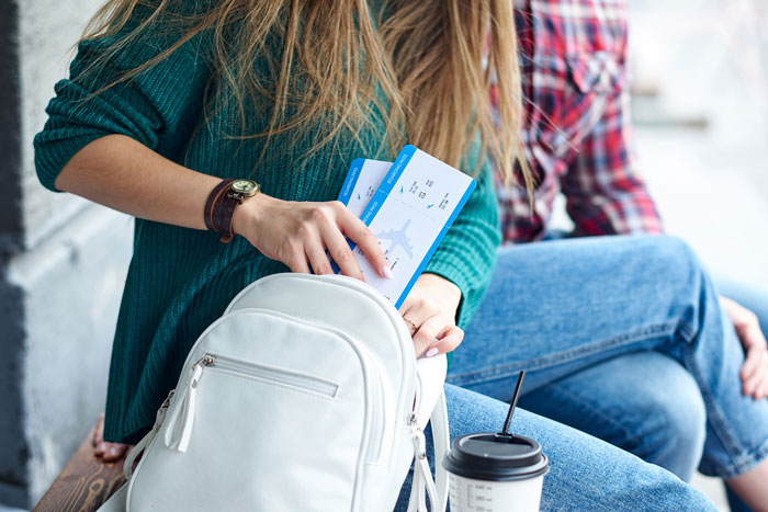 Couple packing flight tickets into backpack as they prepare to babysit nephew for a week without sister paying for flights Couple packing flight tickets into backpack as they prepare to babysit nephew for a week without sister paying for flights