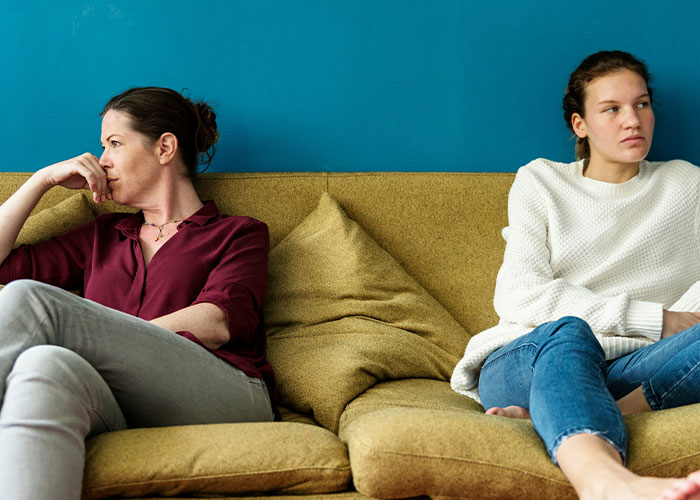 Two women sitting on a couch looking upset and avoiding each other after sister sabotaged birthday dinner conflict. Two women sitting on a couch looking upset and avoiding each other after sister sabotaged birthday dinner conflict.