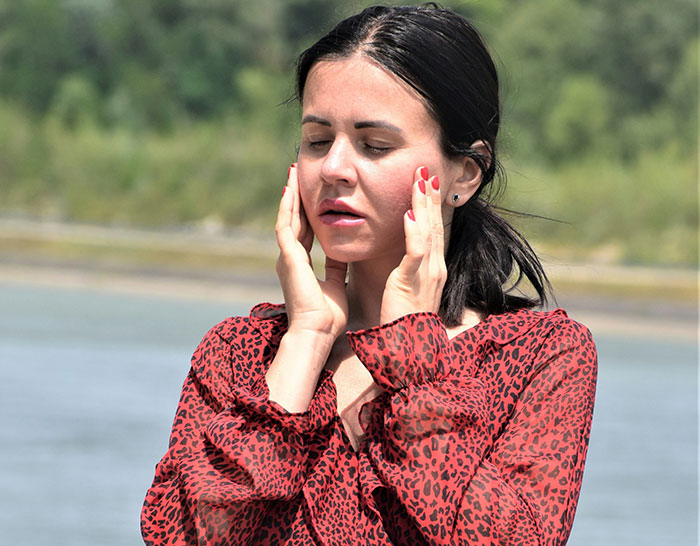 Woman in red blouse looking upset outdoors, reflecting on a ruined graduation day after hubby's unspoken seat change. Woman in red blouse looking upset outdoors, reflecting on a ruined graduation day after hubby's unspoken seat change.