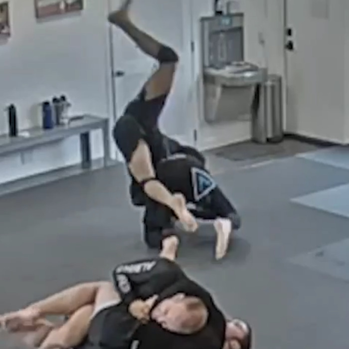 Two jiu-jitsu practitioners sparring in gym highlighting tragic freak accident involving paralyzing injury during training. Two jiu-jitsu practitioners sparring in gym highlighting tragic freak accident involving paralyzing injury during training.