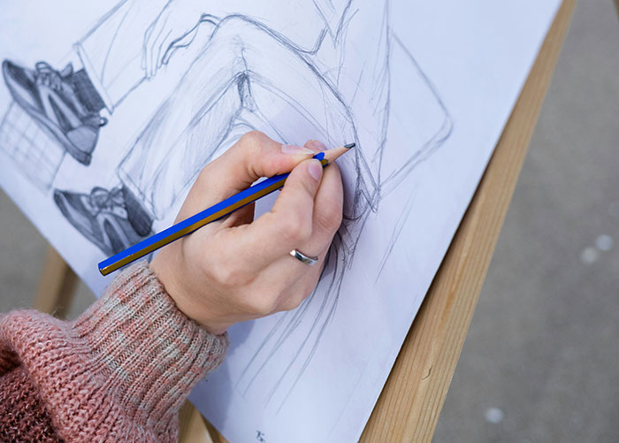 Court sketch artist drawing a detailed courtroom scene with pencil, reflecting on her trial coverage and artistic choices. Court sketch artist drawing a detailed courtroom scene with pencil, reflecting on her trial coverage and artistic choices.