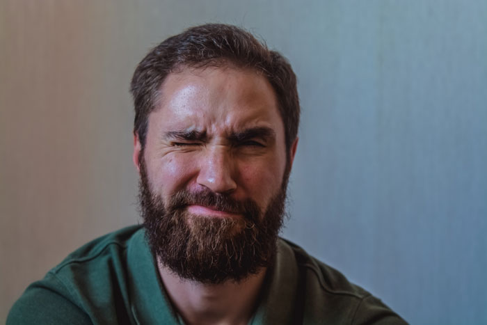 Man with a beard showing frustration after strangers use his patio as their own during his time off. Man with a beard showing frustration after strangers use his patio as their own during his time off.