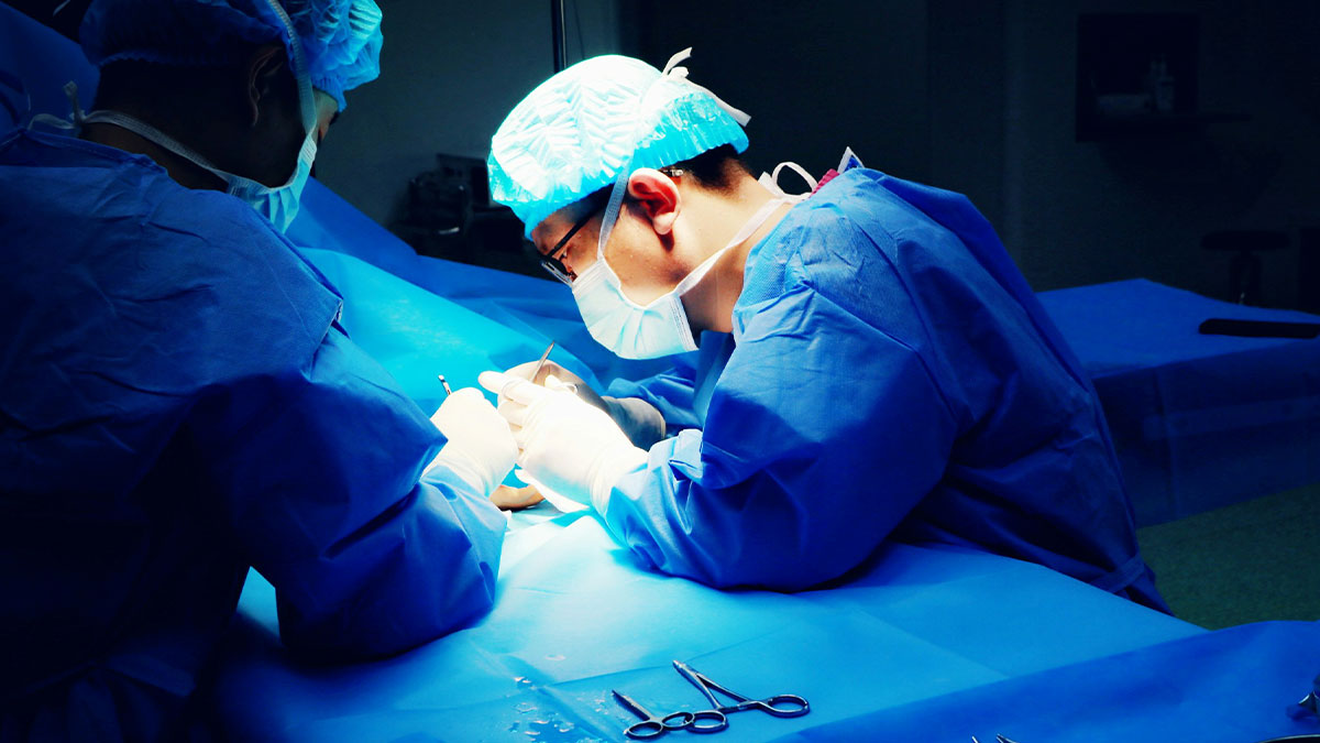Surgeons in blue scrubs performing a detailed operation under bright light, highlighting facts about the human body.