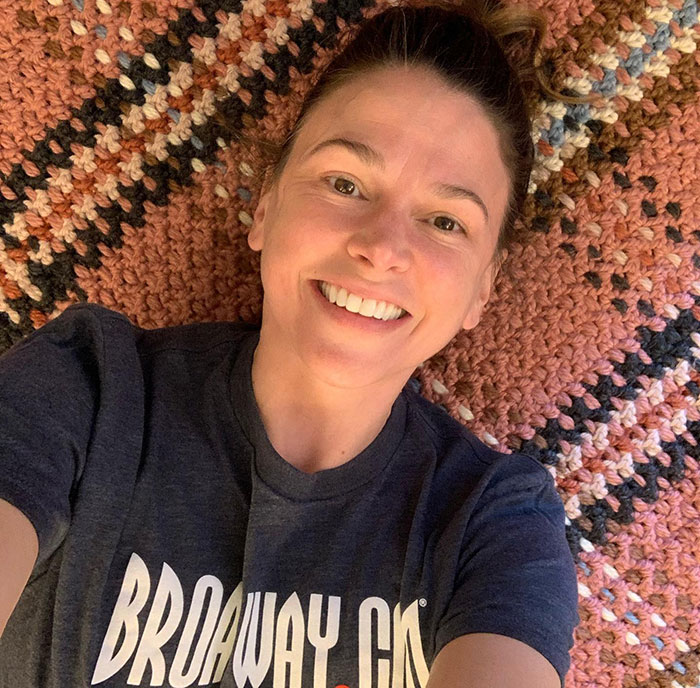 Sutton Foster smiling in a casual selfie wearing a BroadwayCon shirt, highlighting Hugh Jackman's darling and their history. Sutton Foster smiling in a casual selfie wearing a BroadwayCon shirt, highlighting Hugh Jackman's darling and their history.