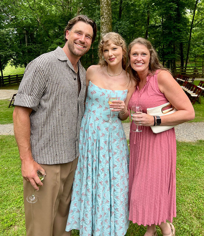Taylor Swift and Travis Kelce posing outdoors with guests, sparking rumors about a secret wedding invitation leak. Taylor Swift and Travis Kelce posing outdoors with guests, sparking rumors about a secret wedding invitation leak.
