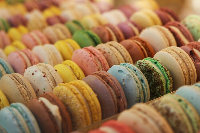 Assorted colorful macarons arranged in rows, illustrating people share most privileged things said through diverse treats.