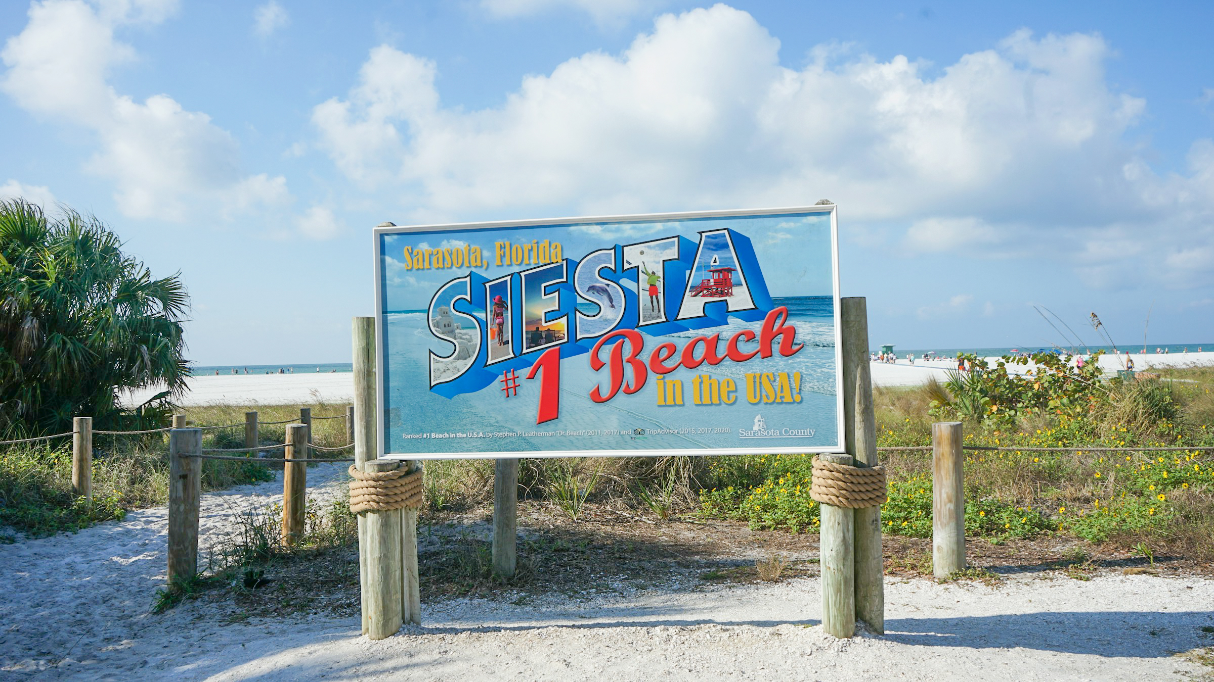 Large colorful sign at Siesta Key beach entrance in Sarasota Florida, highlighting the number one beach in the US with sandy shore and blue sky. Large colorful sign at Siesta Key beach entrance in Sarasota Florida, highlighting the number one beach in the US with sandy shore and blue sky.