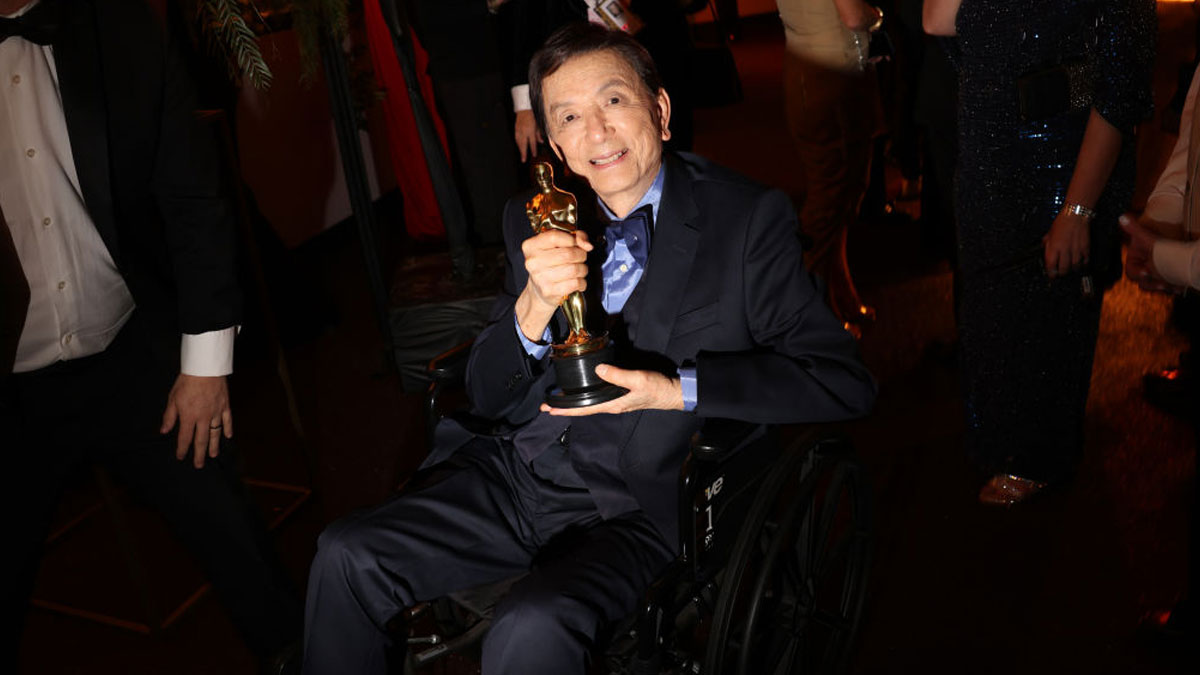 Actor in a wheelchair holding an award statue, celebrating a career in the most movies across every genre event.
