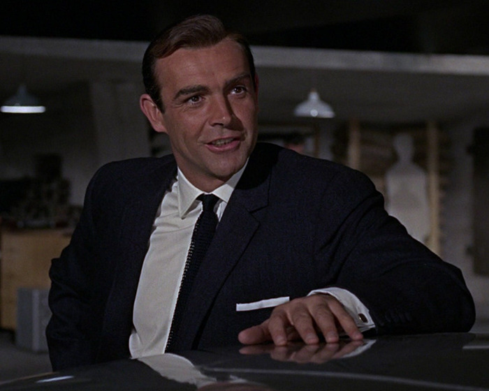 Sean Connery as James Bond in a classic scene wearing a dark suit and tie, captured in a dimly lit setting. Sean Connery as James Bond in a classic scene wearing a dark suit and tie, captured in a dimly lit setting.