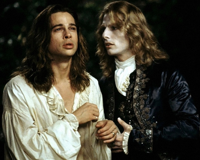 Two men dressed in vintage costumes engaged in an intense conversation under dim lighting. Two men dressed in vintage costumes engaged in an intense conversation under dim lighting.