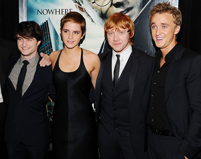 Daniel Radcliffe, Emma Watson, Rupert Grint, and Tom Felton posing together on a red carpet at a Harry Potter event. Daniel Radcliffe, Emma Watson, Rupert Grint, and Tom Felton posing together on a red carpet at a Harry Potter event.