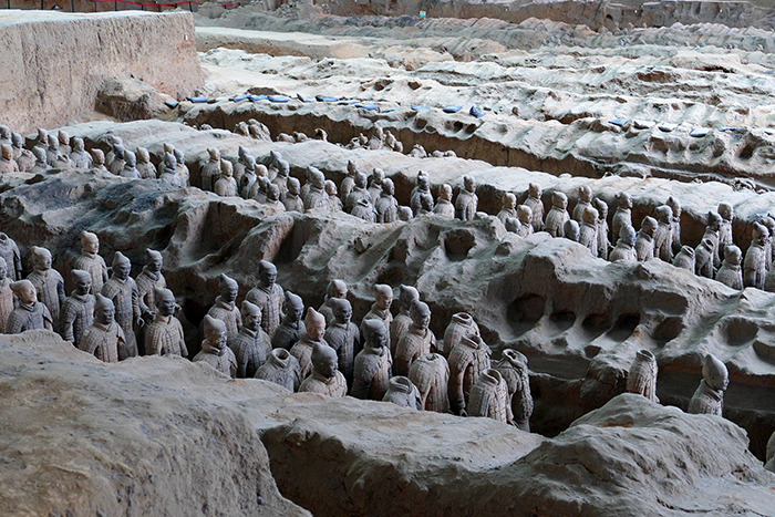 Terracotta army statues in an ancient pit showing 2000-year-old statues damaged by a tourist accident.