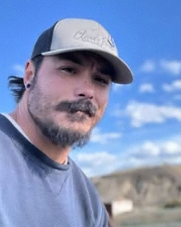 Man wearing a cap outdoors with blue sky, related to bodies of 3 missing sisters found as police hunt for their father. Man wearing a cap outdoors with blue sky, related to bodies of 3 missing sisters found as police hunt for their father.
