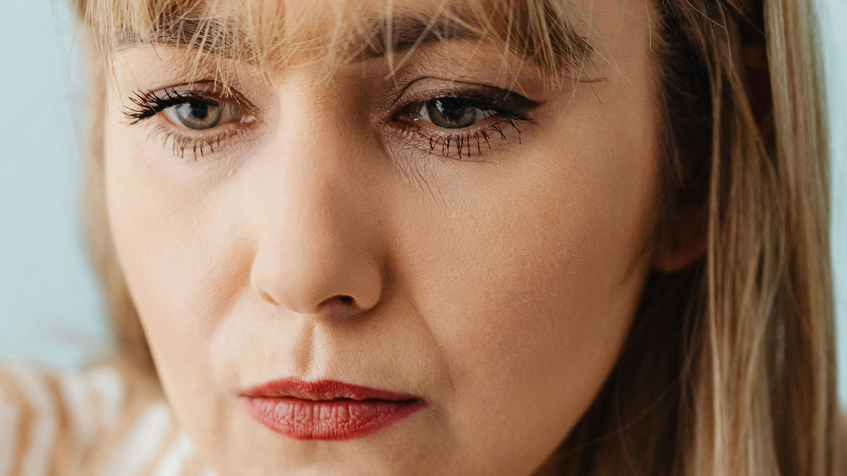 Close-up of a mom-to-be with a thoughtful expression, reflecting on postpartum help and grandparent balance.