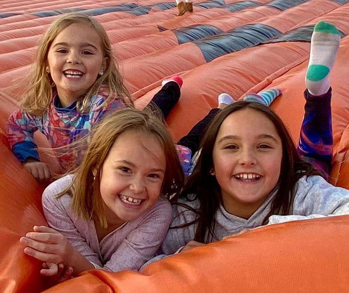 Three young girls smiling and playing on an inflatable surface, unrelated blood found at fugitive dad's crime scene. Three young girls smiling and playing on an inflatable surface, unrelated blood found at fugitive dad's crime scene.