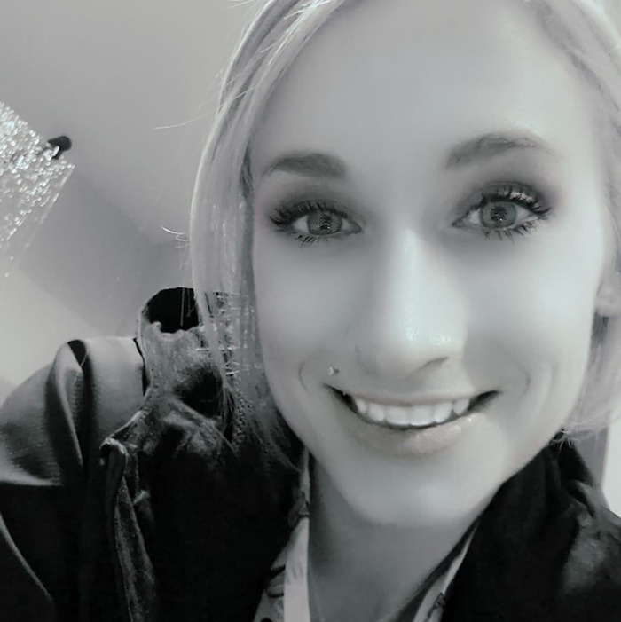 Young caring mother with a portion of jaw missing smiling softly in a close-up black and white portrait indoors. Young caring mother with a portion of jaw missing smiling softly in a close-up black and white portrait indoors.