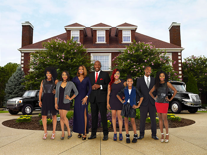 Group of well-dressed adults and children posing in front of a large house, related to former reality TV child star news. Group of well-dressed adults and children posing in front of a large house, related to former reality TV child star news.