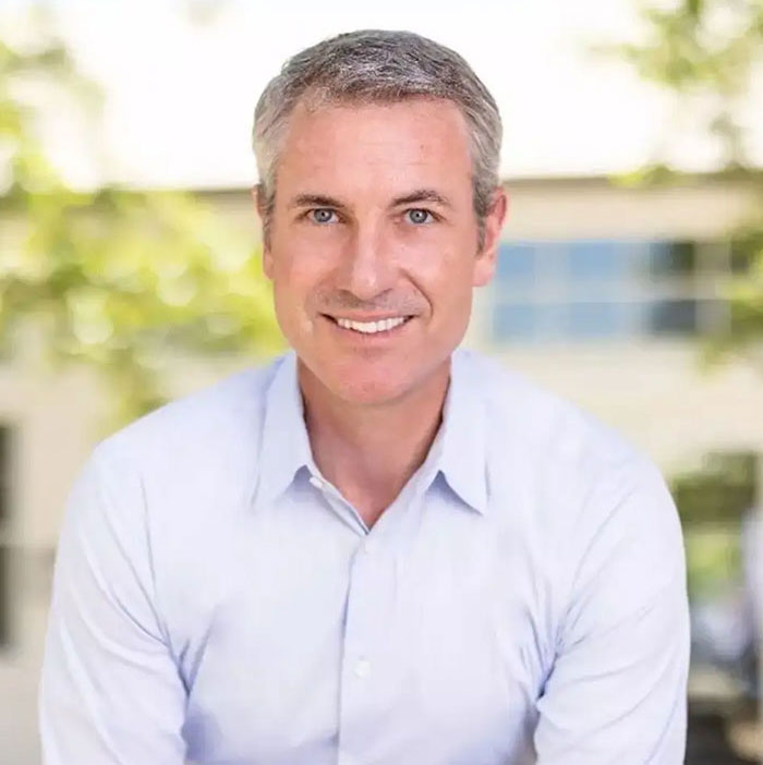 Man in a light blue shirt smiling outdoors, representing Coldplay HR exec mortgage story concept. Man in a light blue shirt smiling outdoors, representing Coldplay HR exec mortgage story concept.