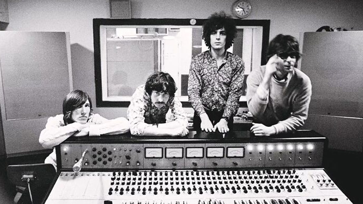 Vintage 1970s rock legends in recording studio, posing behind mixing console during music creation session.