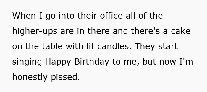Annoyed worker standing by a birthday cake with lit candles as colleagues sing Happy Birthday in an office. Annoyed worker standing by a birthday cake with lit candles as colleagues sing Happy Birthday in an office.
