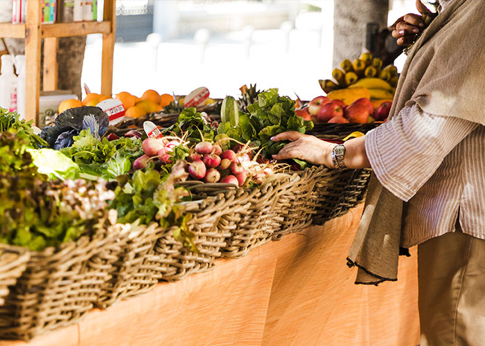 Person picking fresh produce at a farm stand with various vegetables, highlighting issues with a neighbor's farm stand. Person picking fresh produce at a farm stand with various vegetables, highlighting issues with a neighbor's farm stand.