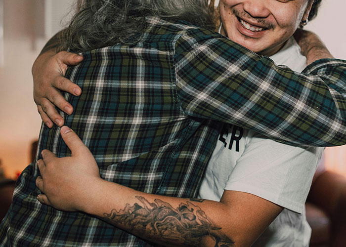Two people hugging warmly, capturing a moment of family connection and sharing bizarre family habits.