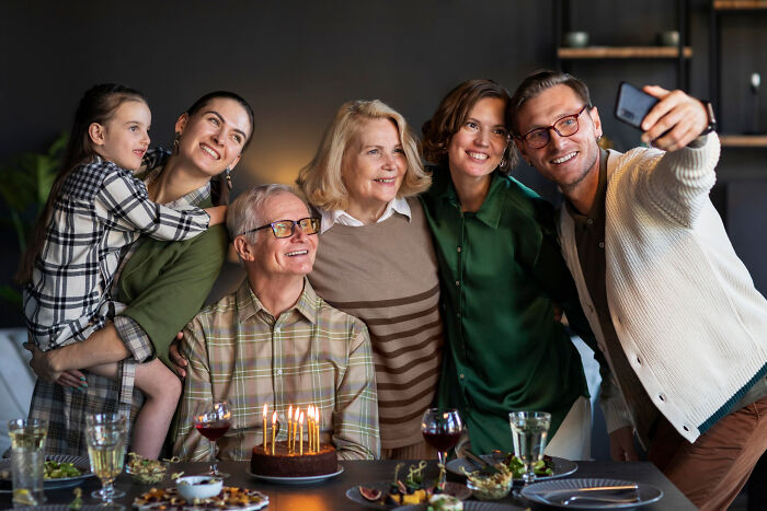 Family celebrating birthday together, capturing moment with a selfie, reflecting the nostalgia of thank you notes fading away.
