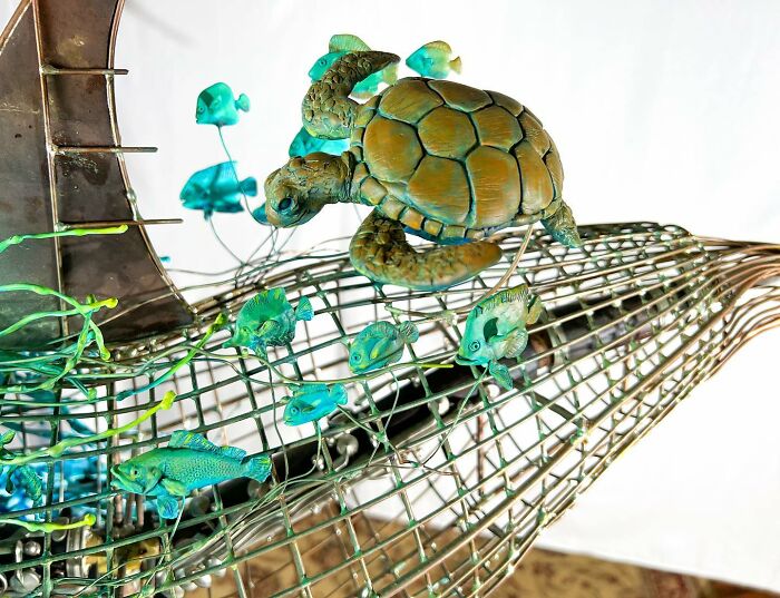 Sculpture of an orca made from scrap metal showcasing striking animal sculptures by an innovative artist.