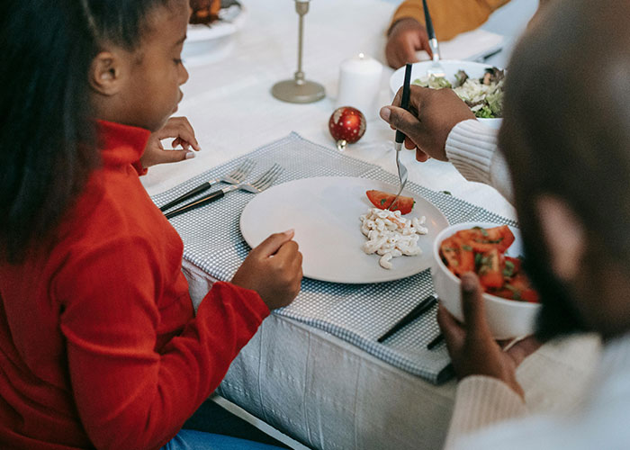 Family sharing a meal with unusual food choices at the dining table, highlighting bizarre family traditions and habits.