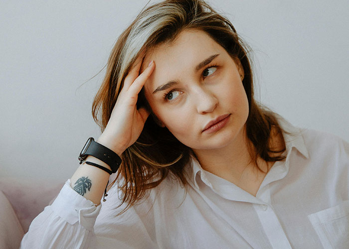 Young woman rethinking her relationship after noticing red-flag behavior, appearing worried and fearful in a casual setting. Young woman rethinking her relationship after noticing red-flag behavior, appearing worried and fearful in a casual setting.