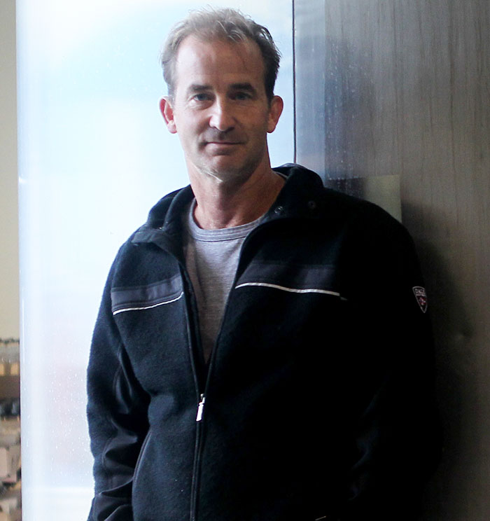 Man in casual jacket standing indoors near window, related to Coldplay HR exec mortgage news story. Man in casual jacket standing indoors near window, related to Coldplay HR exec mortgage news story.