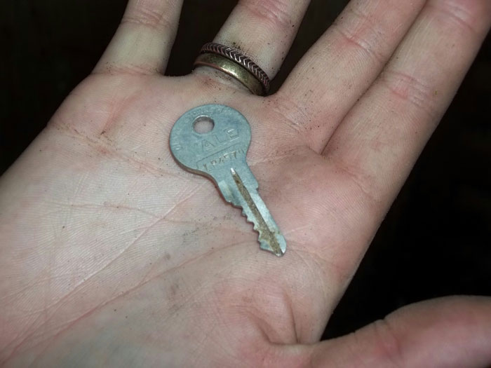 Hand holding a storage unit key left by dad, symbolizing discovery and changing perceptions forever. Hand holding a storage unit key left by dad, symbolizing discovery and changing perceptions forever.