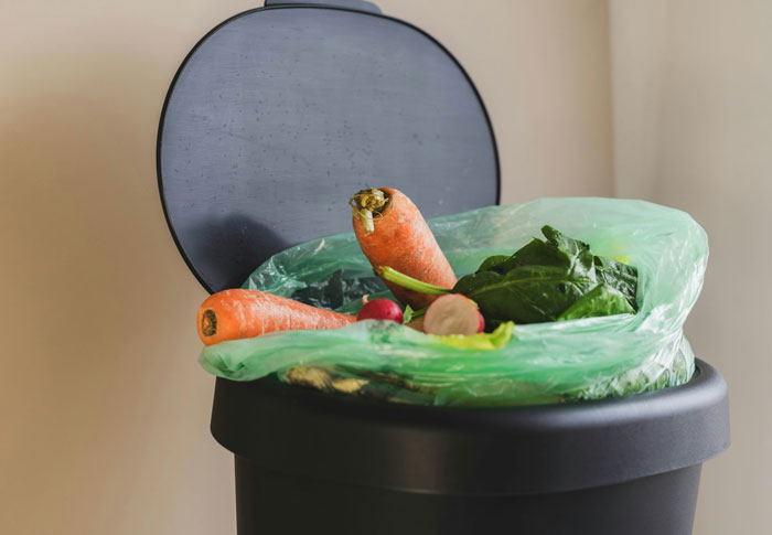 Trash bin with discarded vegetables including carrots and leafy greens, illustrating entitled family behavior consequences.