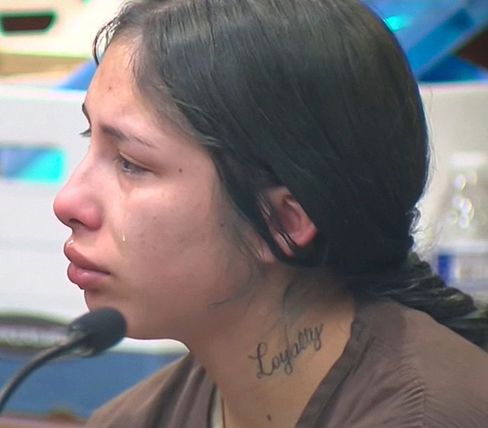 Woman with tear-streaked face and loyalty tattoo on neck sobbing in court over tougher charges after baby lost life in car.